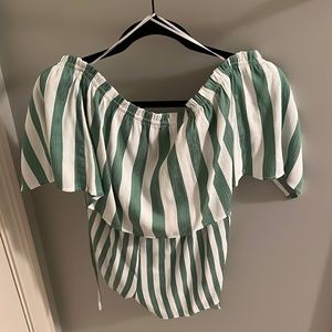 A green and white, off the shoulders romper. Not form fitting at all.